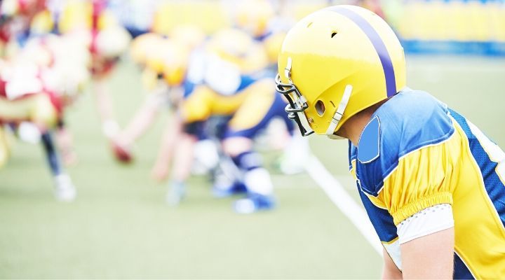 A wide receiver wearing blue and yellow uniform getting ready to catch the ball during a game