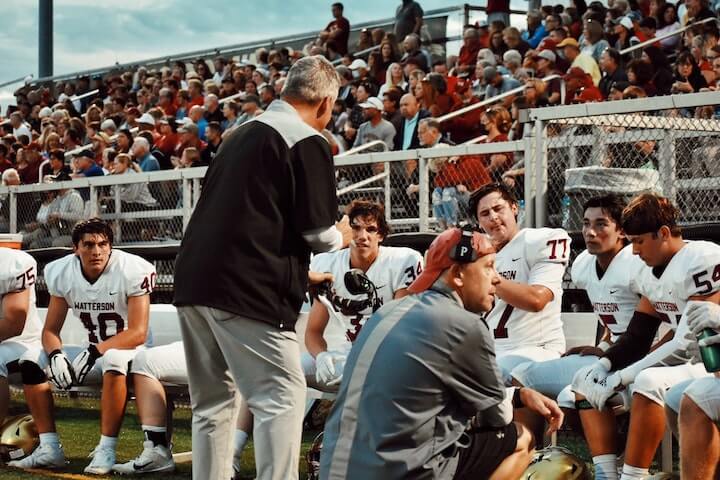 football-coach-talks-to-his-players-during-a-timeout-to-stop-the-clock