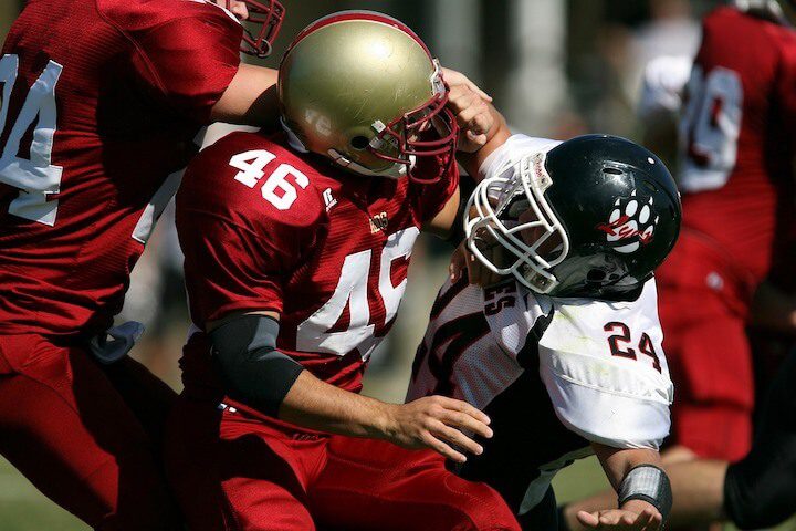 a defensive end tries to get past an offensive lineman during a football game